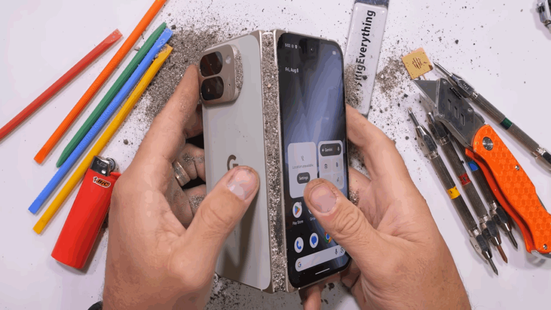 Le Pixel 10 Pro Fold pendant le test de résistance, avec du sable introduit dans la charnière pour vérifier la protection IP68.