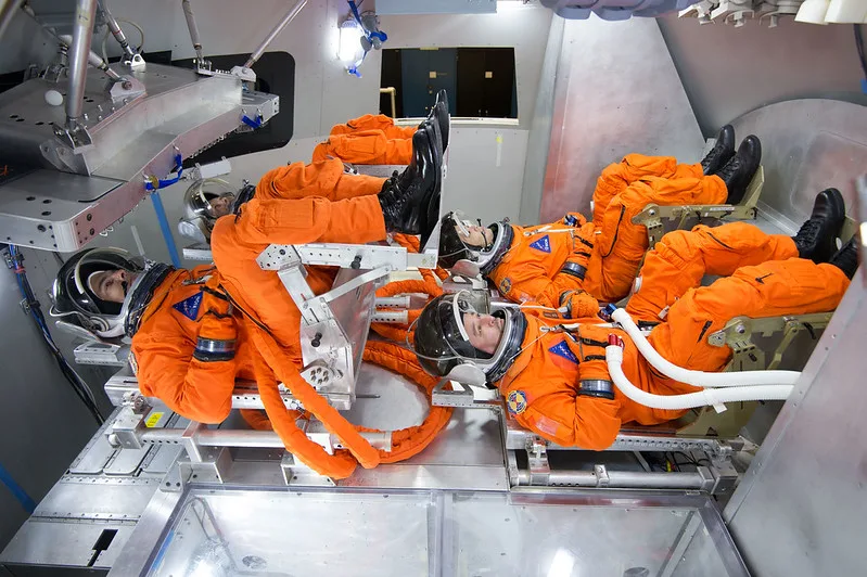 Spacesuit engineers demonstrate how four crew members would be arranged for launch inside the Orion spacecraft, using a mockup of the vehicle at Johnson Space Center in Houston. Photo credit: NASA/Robert Markowitz